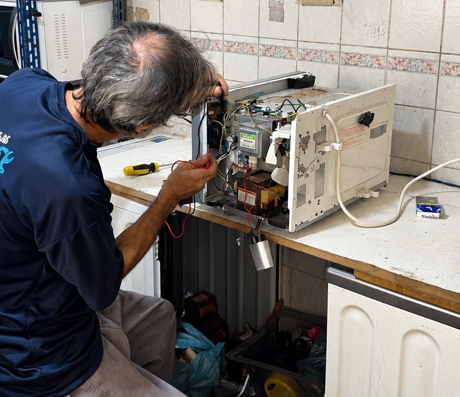 Técnico realizando conserto de micro-ondas