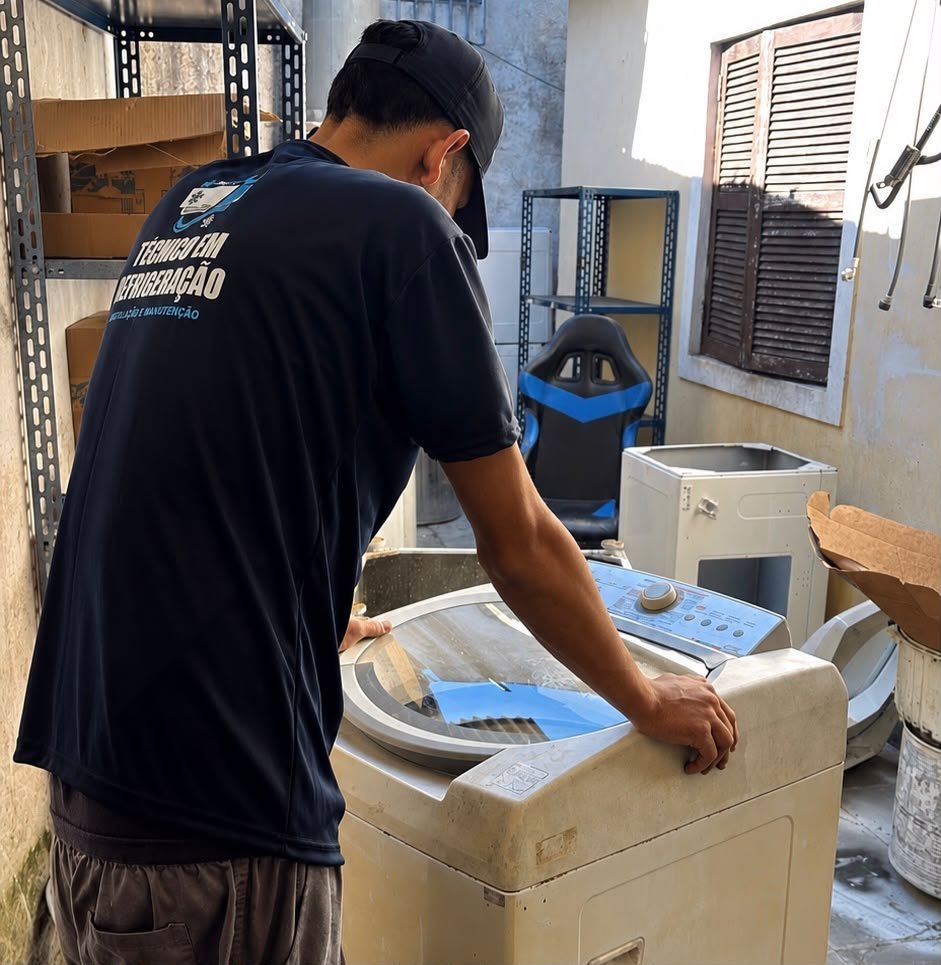Técnico realizando conserto de máquina de lavar